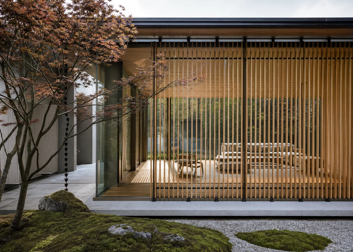 glass house front design: Glass house front screened by timber slats casting shadow patterns