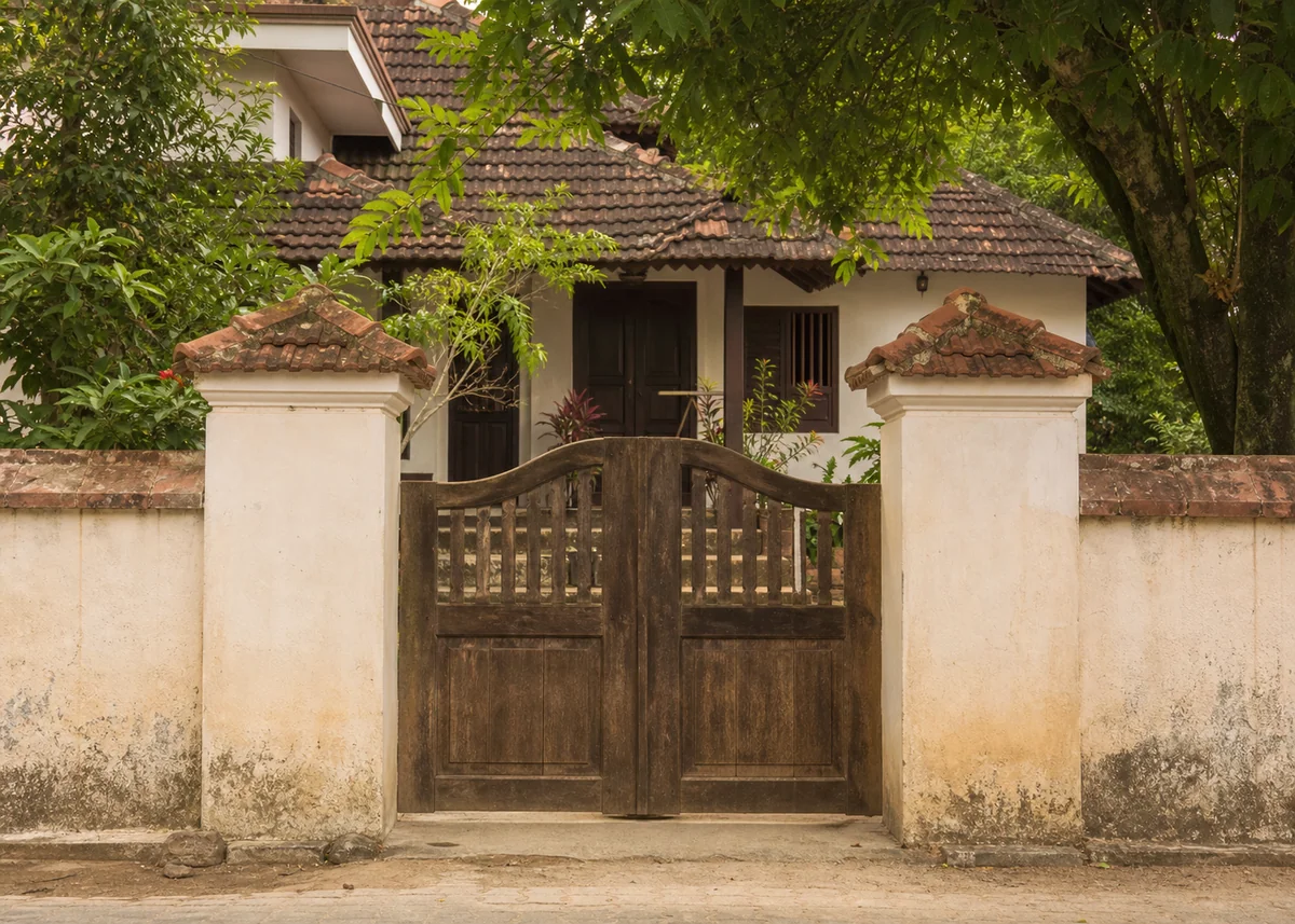village house front design: Village compound gate with tile-capped piers and timber leaves